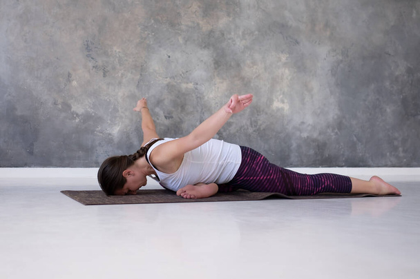 Femme pratiquant le yoga préparant Eka Pada Rajakapotasana en studio
 - Photo, image