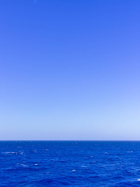 鮮やかな青い海と空、コピースペース付きの垂直画像. - 写真・画像