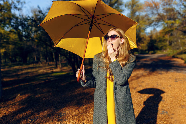 Stylish girl with yellow umbrella in autumn Park. Autumn time - Fotoğraf, Görsel