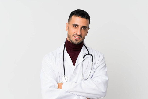 Mladý muž přes izolované bílé pozadí s lékařem šaty - Fotografie, Obrázek