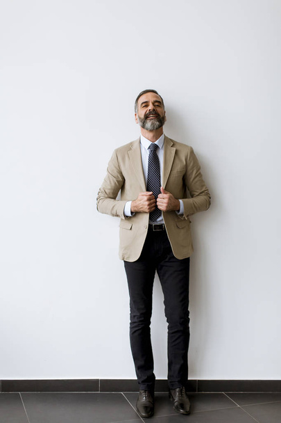 Portret de barbudo guapo hombre de negocios de mediana edad por la pared
 - Foto, imagen