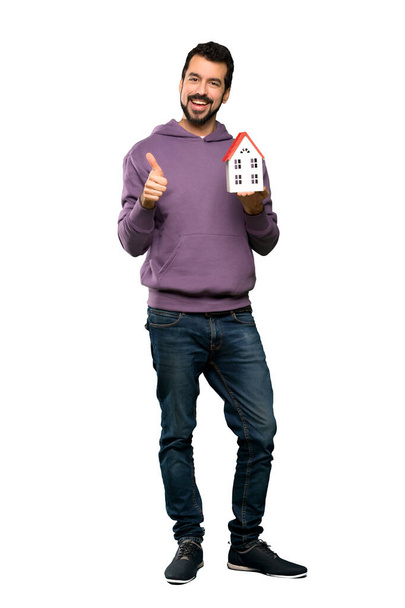 Handsome man with sweatshirt holding a little house - Foto, Imagem