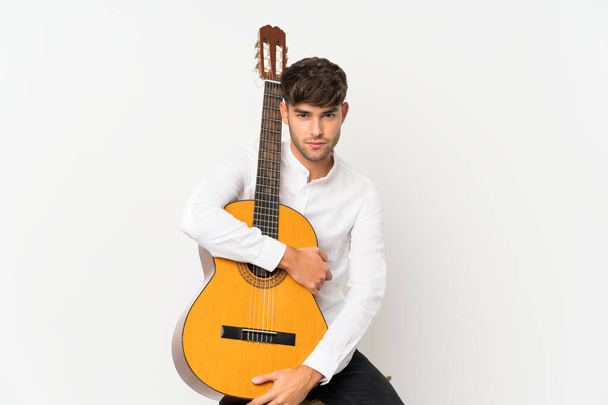 Young handsome man with guitar over isolated white background - Photo, image