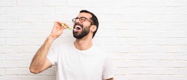 Hombre con barba cepillándose los dientes
 - Foto, Imagen