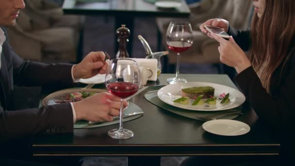 Biznes kobieta fotografuje jedzenie na smartfonie w restauracji - Materiał filmowy, wideo
