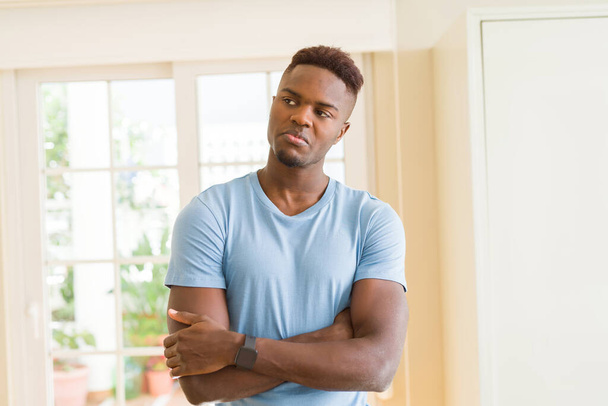 Handsome african man standing comfortable with crossed arms and looking relaxed - Photo, Image