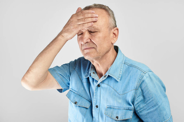 elderly gray-haired man with expression of pain on face put his hand on head, feels dizzy and cluster headache, migraine, high or low blood pressure isolated on white - Φωτογραφία, εικόνα