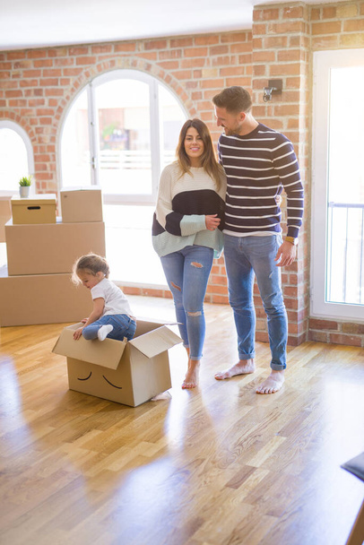 Hermosa familia, niño jugando con sus padres montar caja de cartón fanny en un nuevo hogar
 - Foto, imagen