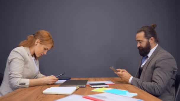 Geschäftsleute sitzen mit Geräten im Besprechungsraum - Filmmaterial, Video