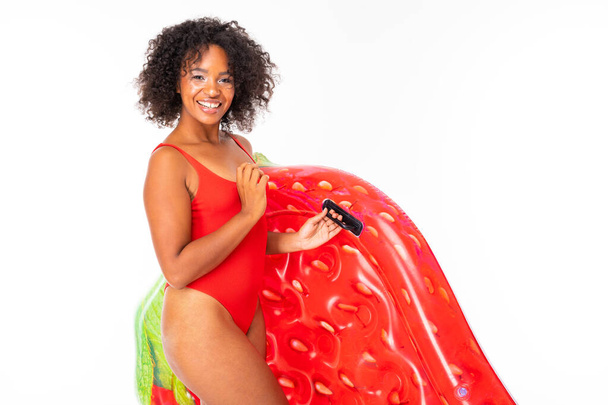 African woman in swimwear posing with air mattress against white background  - Foto, imagen