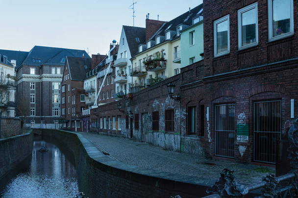 kilátás a csatornára és az esti városi utcára alacsony régi házakkal, Düsseldorf, Németország, 2018. december 10. - Fotó, kép