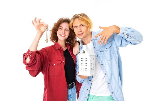 Woman and man posing with house layout against white background  - Foto, Imagen