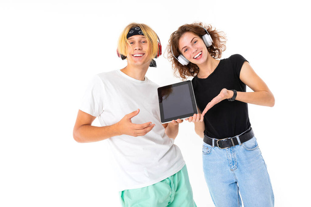 Mulher e homem posando em fones de ouvido com tablet digital contra fundo branco
   - Foto, Imagem