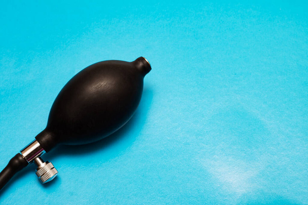Musta päärynä tonometri lähikuva sinisellä taustalla
 - Valokuva, kuva