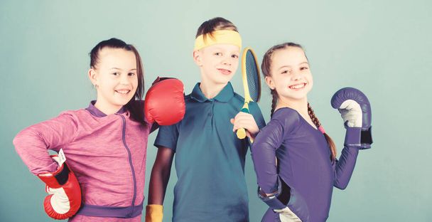 Sporty siblings. Girls kids with boxing sport equipment and boy tennis player. Ways to help kids find sport they enjoy. Friends ready for sport training. Child might excel completely different sport - Фото, изображение