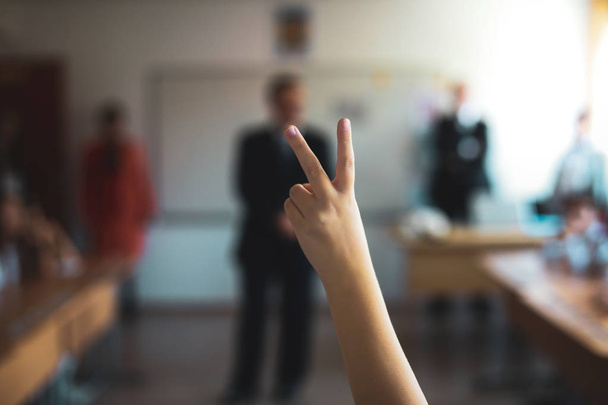 Profundidade rasa da imagem de campo com um aluno levantou a mão para responder
  - Foto, Imagem