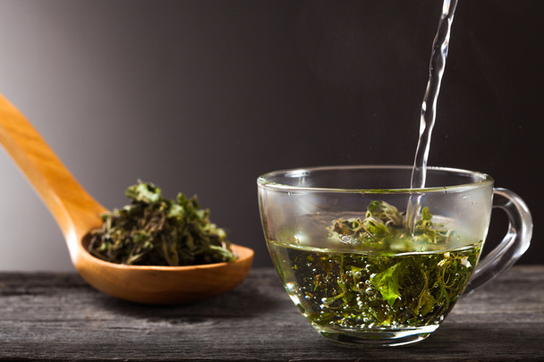 Tasse de thé à la menthe verte et cuillère à thé à la menthe sèche
 - Photo, image
