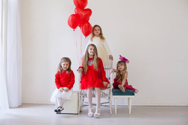 чотири дівчини в червоно-білому одязі з повітряними кулями
 - Фото, зображення