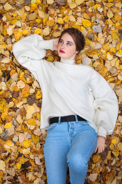 Top view portrait of a young beautiful woman in a white sweater - Foto, Imagen
