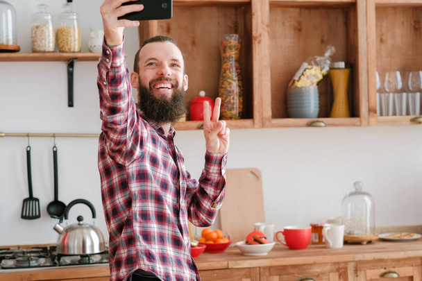 social media addiction bearded guy selfie kitchen - 写真・画像