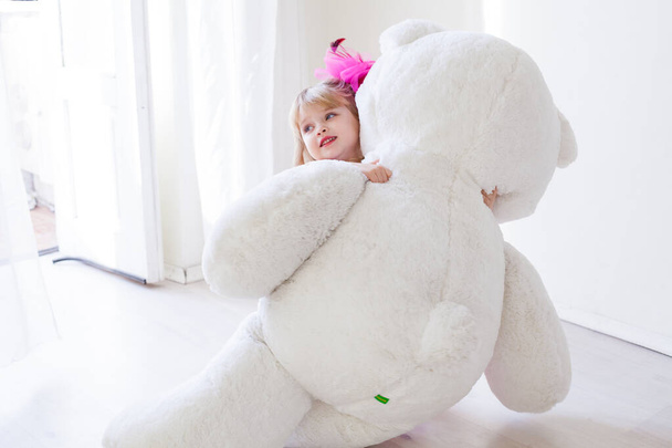 Little girl with big soft toy polar bear - Foto, Imagen