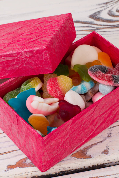 Różne cukierki galaretki w różowym pudełku. - Zdjęcie, obraz