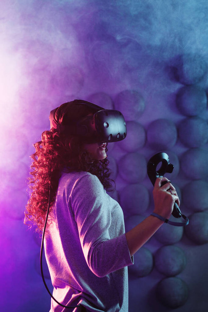 gamer in virtual reality, a girl plays a game or explores the environment in a simulation. - Foto, Imagem