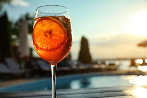 Glass of fresh summer cocktail at poolside outdoors at sunset. Space for text - Fotoğraf, Görsel