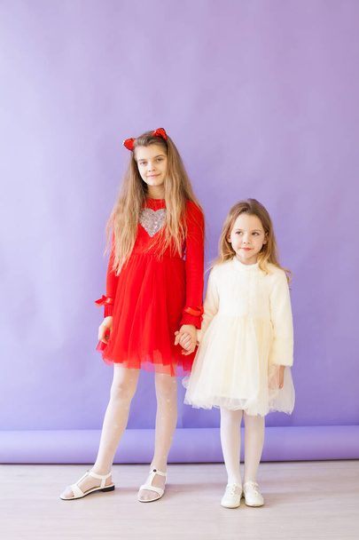 Two beautiful girls in red and white dresses - Φωτογραφία, εικόνα