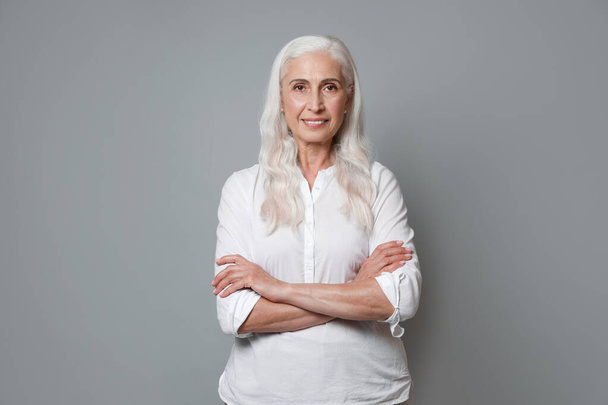 Portrait of beautiful mature woman on grey background - Zdjęcie, obraz