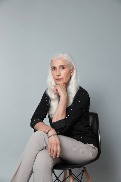 Portrait of beautiful mature woman on grey background - Fotografie, Obrázek