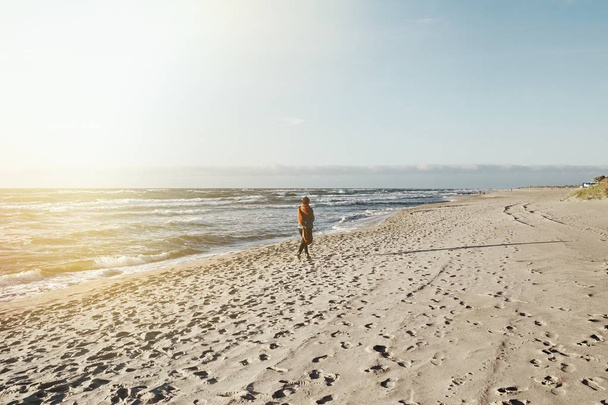 Γυναίκα βόλτες στην παραλία ηλιοβασίλεμα, vintage στυλ. - Φωτογραφία, εικόνα