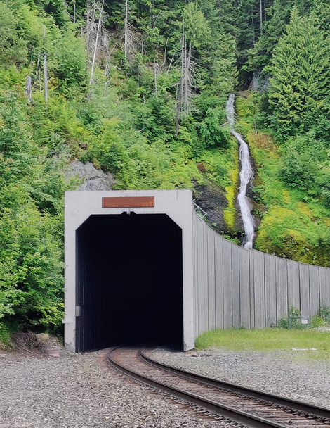 Washington eyaletinin Stampede bölgesinde bulunan küçük ve ücra bir kasaba olan Marvin 'de tren tüneli ve rayları olan Snowshoe Şelaleleri' nin inanılmaz hava fotoğrafları. - Fotoğraf, Görsel