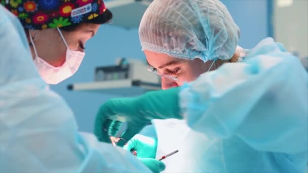 Een medisch team van chirurgische specialisten werkzaam in de moderne operatiekamer van het ziekenhuis, het uitvoeren van teamvoorbereiding van de patiënt voor chirurgie. - Video