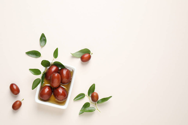 Sauce boat with jojoba oil and seeds on light background, flat lay. Space for text - Foto, immagini