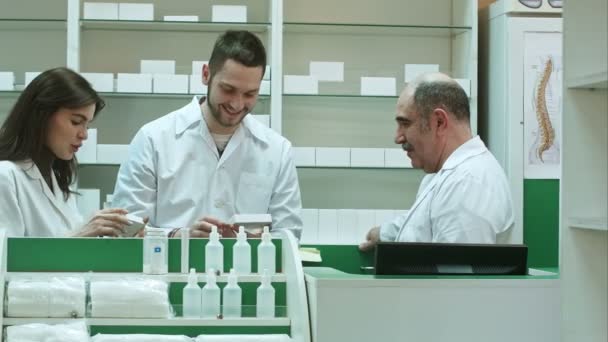 Équipe positive de pharmaciens regardant la boîte de comprimé à la pharmacie de l'hôpital
 - Séquence, vidéo