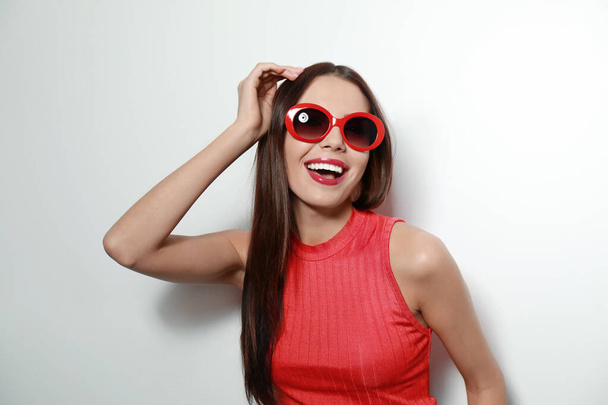 Beautiful woman in stylish sunglasses on light background - Photo, image