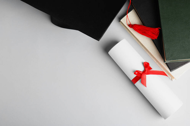 Καπέλο αποφοίτησης, βιβλία και δίπλωμα μαθητή λευκό φόντο, κορυφαία άποψη. Χώρος για κείμενο - Φωτογραφία, εικόνα
