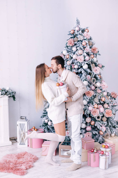 menina segurando presente e casal no amor beijando perto da lareira e
  - Foto, Imagem