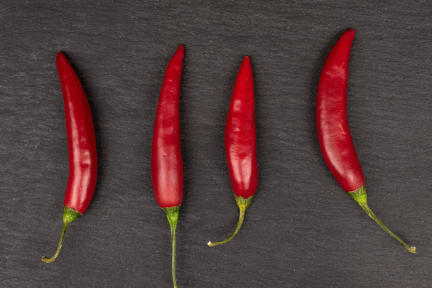 Red hot cayenne chili on grey stone - Foto, Imagen