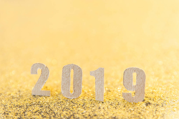 2019 new year text with brown paper on gold glitter background.  - Foto, afbeelding