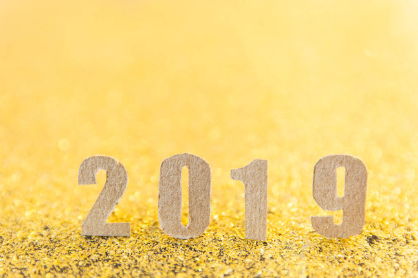 2019 nouveau texte de l'année avec du papier brun sur fond de paillettes d'or
.  - Photo, image