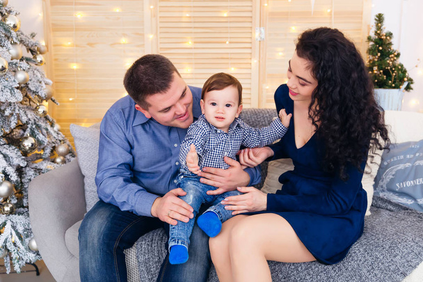 Eltern mit Baby bei einem Weihnachts-Fotoshooting. Familiensitzungen - Foto, Bild