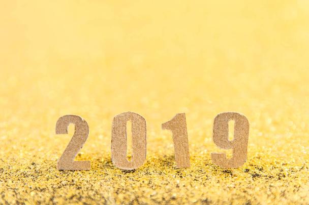 金の輝きの背景に茶色の紙と2019年の新年のテキスト.  - 写真・画像