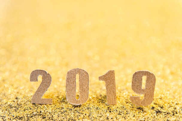 2019 texto del nuevo año con papel marrón sobre fondo de brillo dorado
.  - Foto, Imagen