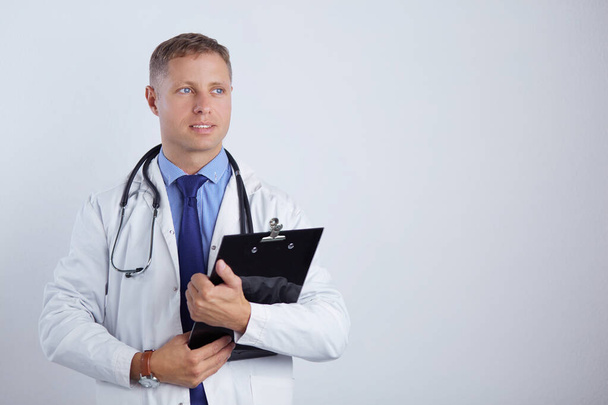 Arzt steht mit Ordner, isoliert auf weißem Hintergrund - Foto, Bild