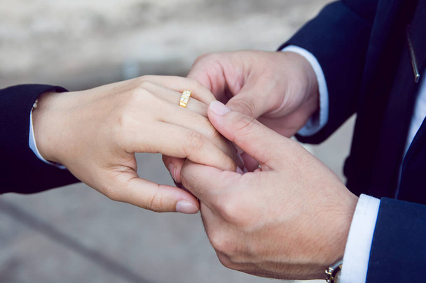Groom usa o anel no dedo da noiva
 - Foto, Imagem