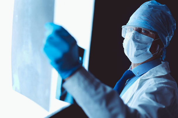 Young doctor looking X-Ray image on isolated white background - Valokuva, kuva