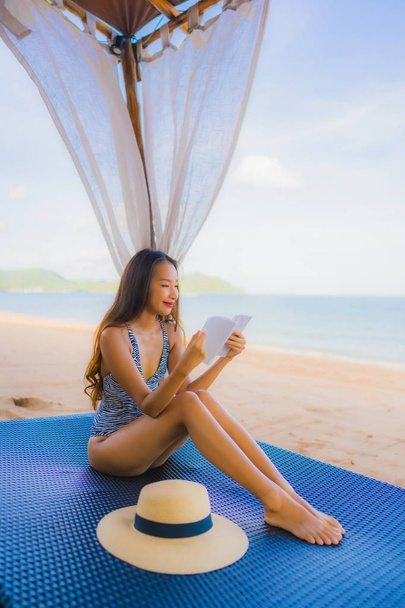 Portrét krásná mladá asijská žena četla knihu s šťastným SMI - Fotografie, Obrázek