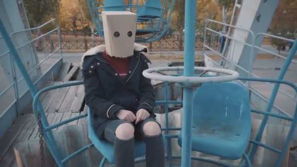 Girl with a pack on his head sits on the old attraction. Girl in a jacket - Footage, Video